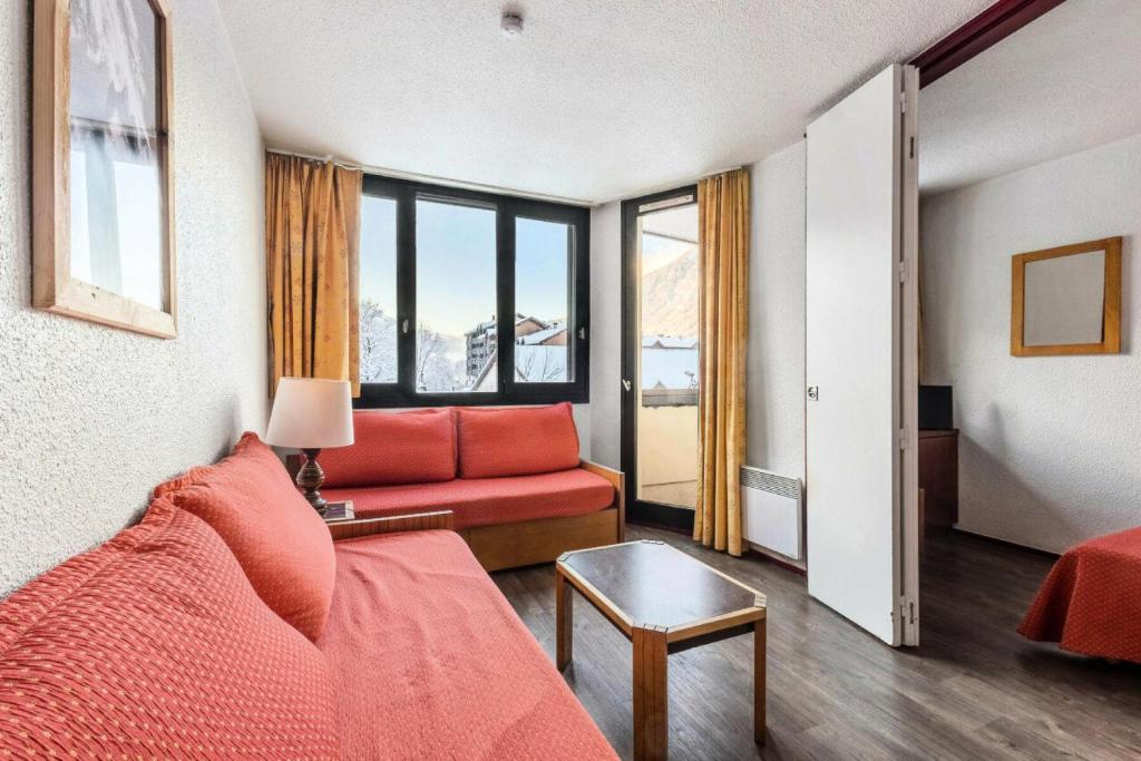 - un salon avec un canapé rouge et une fenêtre dans l'établissement L'Aiguille - maeva Home - Appartement 2 pièces 5 personnes Confort 19, à Chamonix-Mont-Blanc