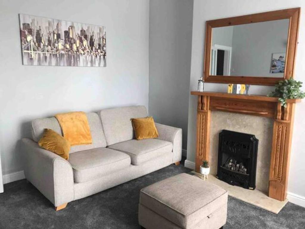 a living room with a couch and a fireplace at 3 Bedroom House Brighouse in Brighouse