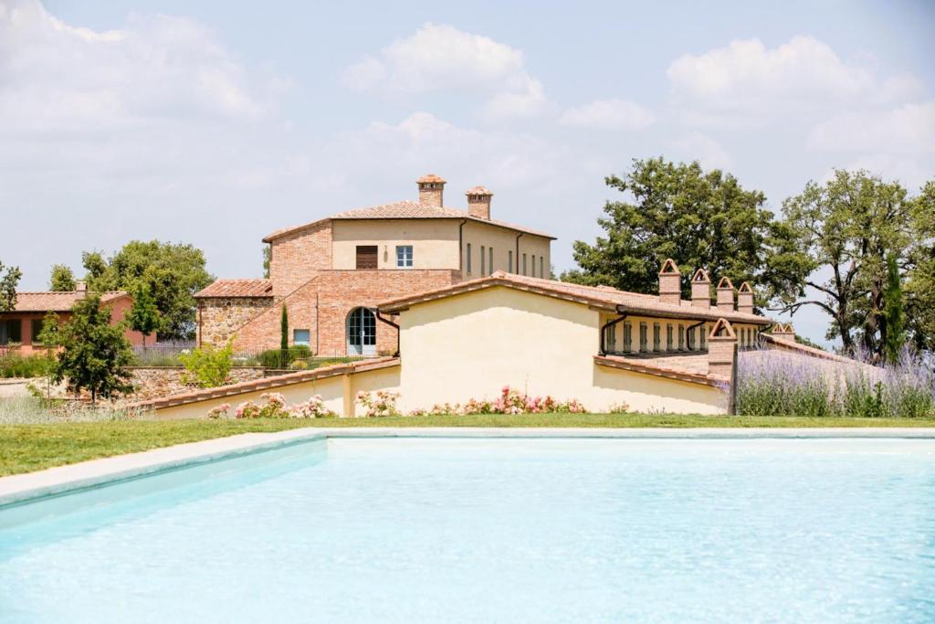 a villa with a swimming pool in front of a house at Luxury Resort with swimming pool in the Tuscan countryside, Villas on the ground floor with private outdoor area with panoramic view in Osteria Delle Noci