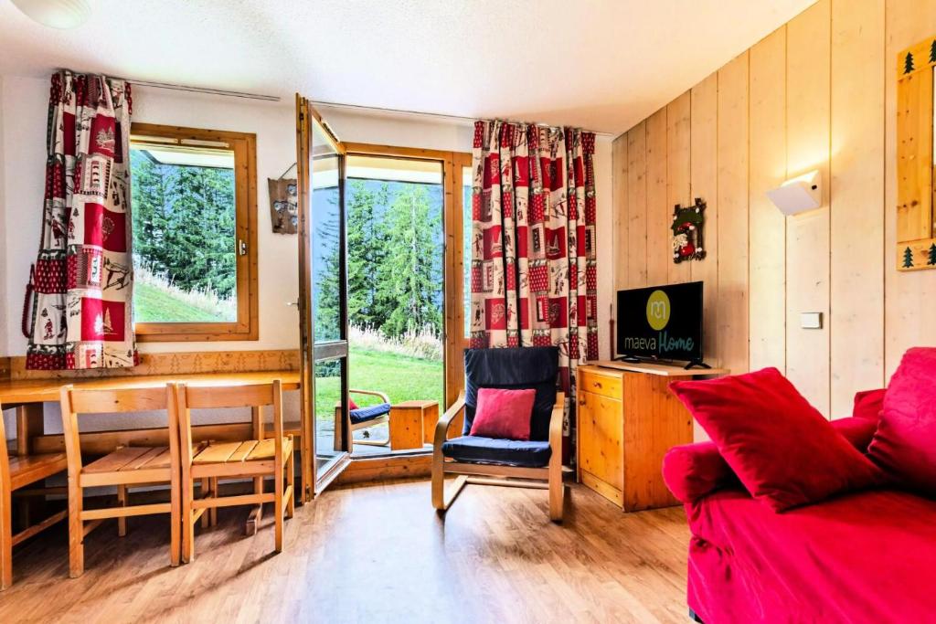 クールシュヴェルにあるRésidence Les Brigues - maeva Home - Appartement 2 Pièces 6 Personnes - Co 014のリビングルーム(赤いソファ、テーブル、椅子付)