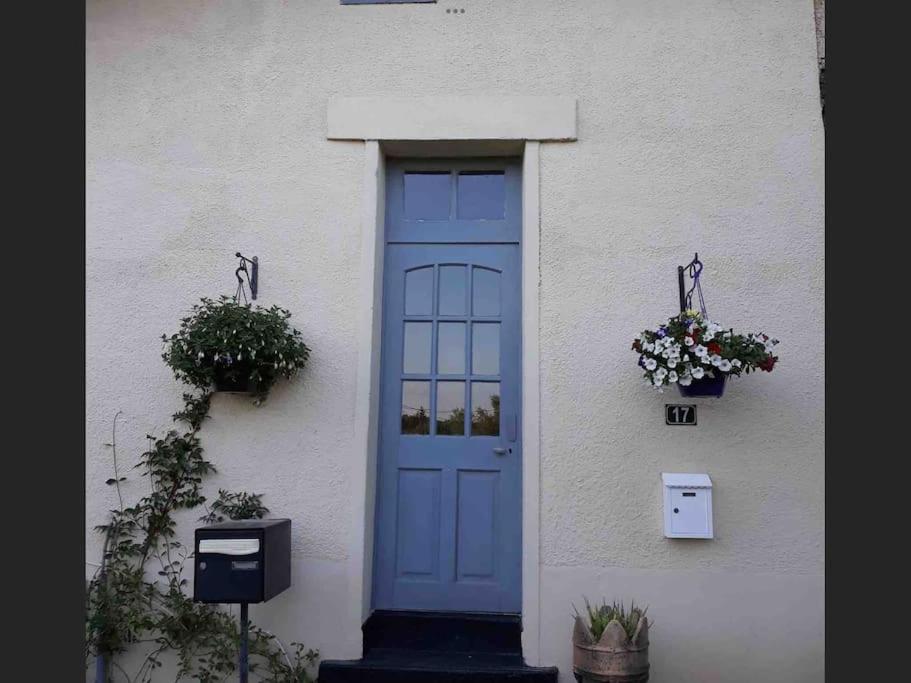 una puerta azul en el lateral de un edificio blanco en Cherry Blossom Cottage en Gorre