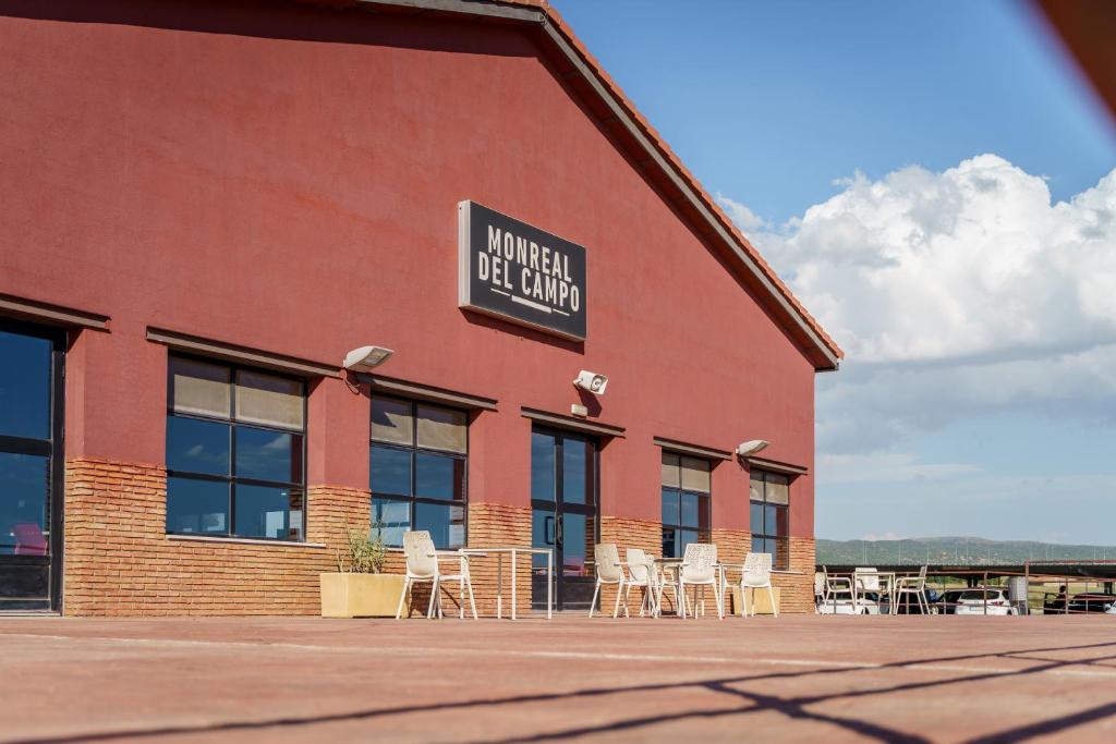 a red brick building with chairs and a sign on it at AS Monreal del Campo in Monreal del Campo