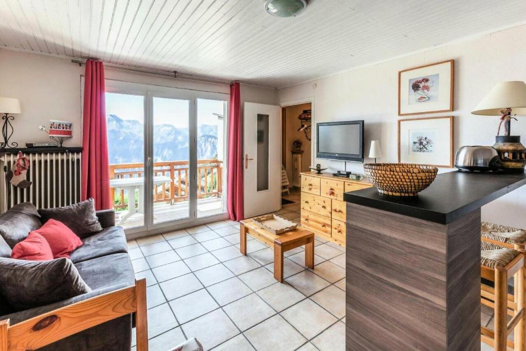 un salon avec un canapé et une télévision dans l'établissement Appartement à l'Alpe d'Huez retour skis aux pieds - maeva Home - Appartement skis aux pieds vue montagne 2 pièces 5 personnes - Sélection MAE-2614, à Huez