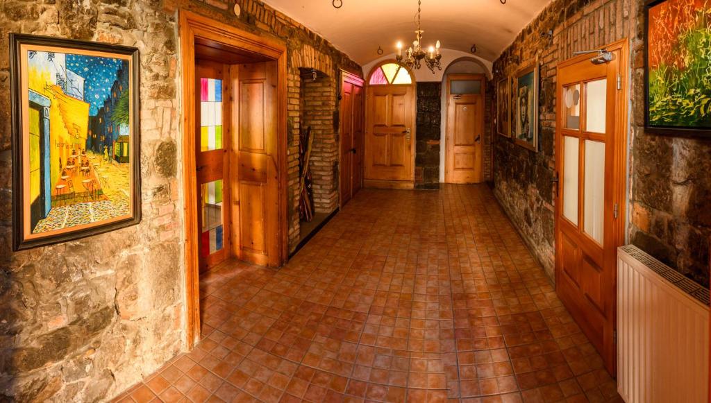 einen Flur mit Fliesenboden und Gemälden an den Wänden in der Unterkunft LAAS ART GALLERY in Stari Trg pri Ložu