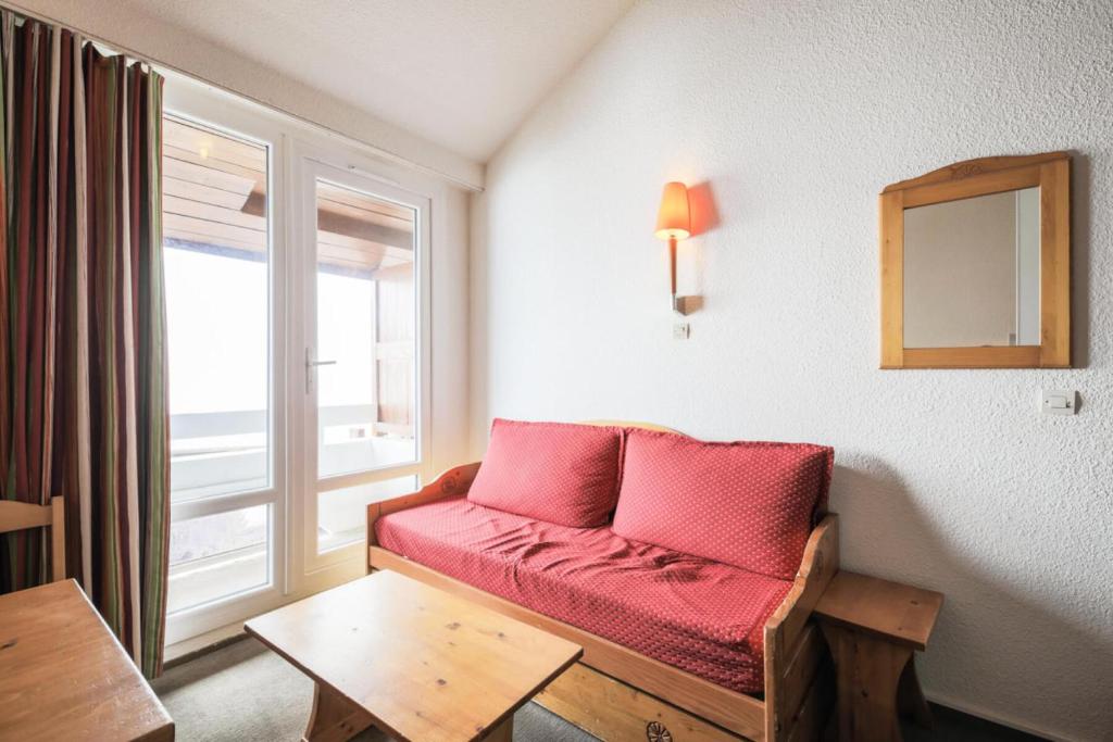 - un canapé rouge dans une chambre avec fenêtre dans l'établissement Résidence Les Horizons d'Huez - maeva Home - Appartement 2 Pièces 6 Personnes - Budget MAE-7008, à Huez