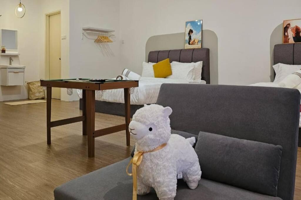 a teddy bear sitting on a couch in a living room at Home at Indera Mahkota Kuantan Unifi 100mb+ TV BOX in Kuantan