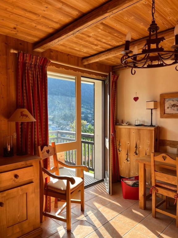 a dining room with a table and a large window at Appartement cosy, esprit chalet avec jolie vue in Saint-Gervais-les-Bains