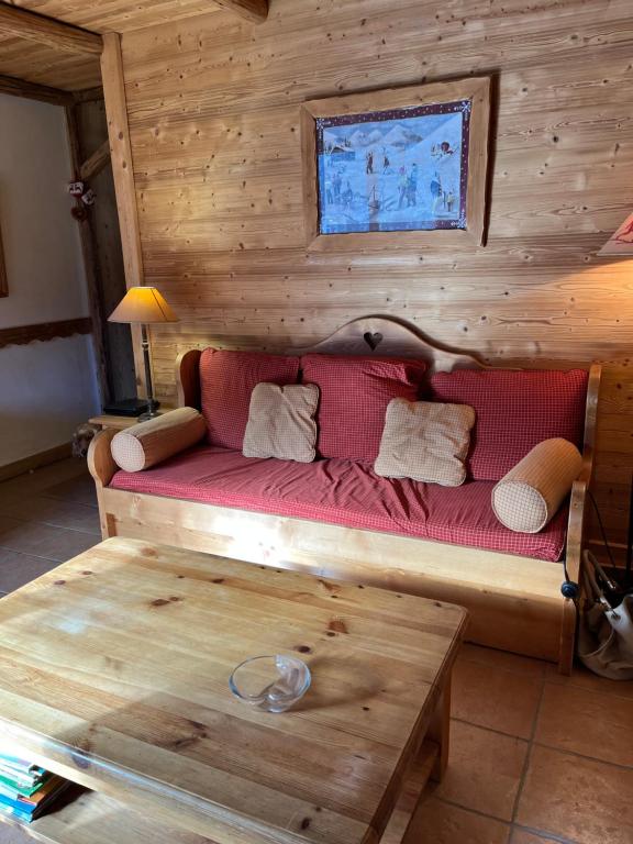 a living room with a red couch and a coffee table at Appartement cosy, esprit chalet avec jolie vue in Saint-Gervais-les-Bains