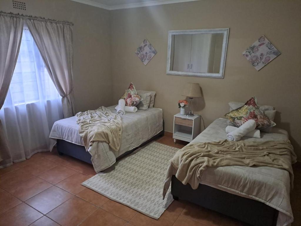 a bedroom with two beds and a window at M&M Self Catering in Richards Bay