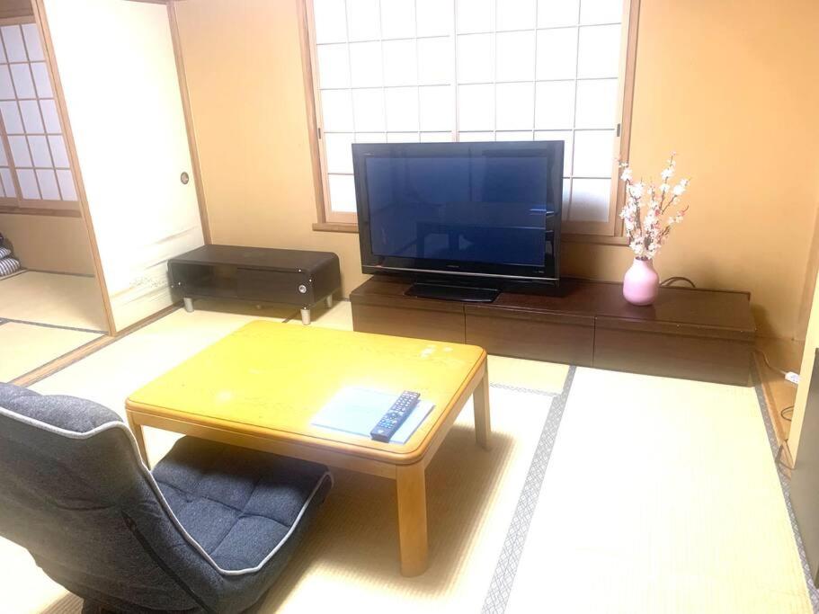 a living room with a coffee table and a television at Tokyo KD House 301 in Tokyo