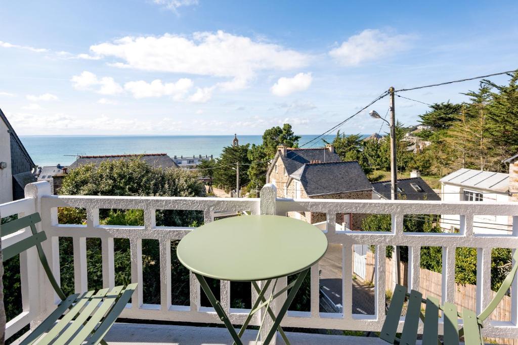 - un balcon blanc avec une table et une vue sur l'océan dans l'établissement Le Crayon - A 200m de la plage, à Pléneuf-Val-André