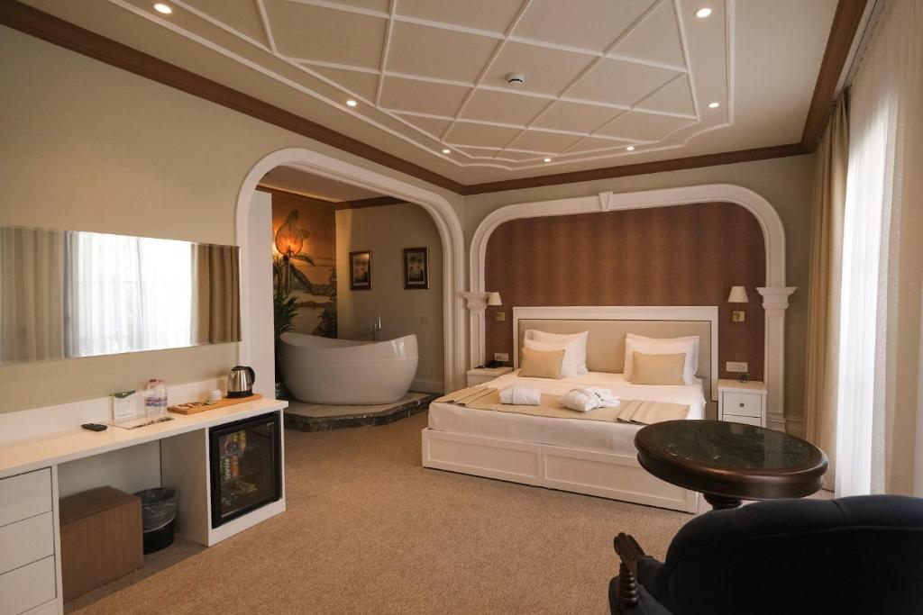1 dormitorio con 1 cama grande y bañera en Mono Life Hotel en Bayrakli