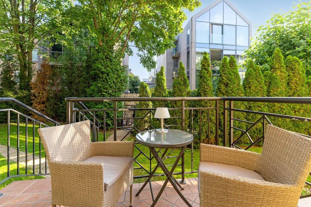 a patio with two chairs and a table on a balcony at Patio Mare - Garden by Grand Apartments in Sopot