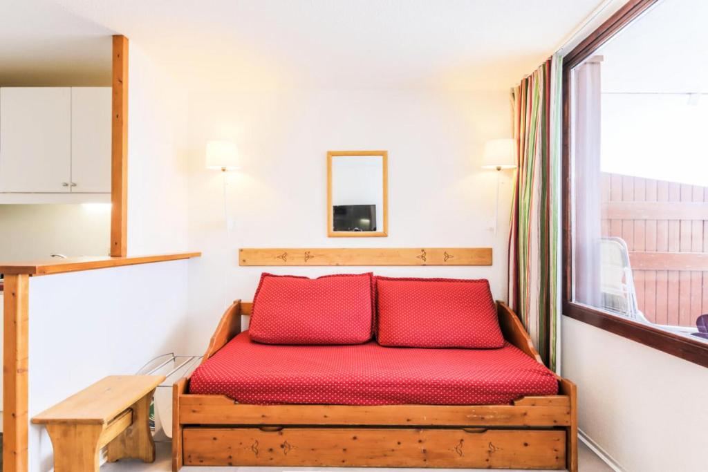 - une chambre avec un lit rouge et une fenêtre dans l'établissement Résidence Les Mélèzes - maeva Home - 2 Pièces 6 Personnes Sélection MAE-5685, à Huez