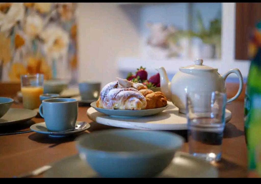 stół z dzbankiem do herbaty i talerzem jedzenia w obiekcie Lovely holiday home next to Bus terminus w mieście St Paul's Bay