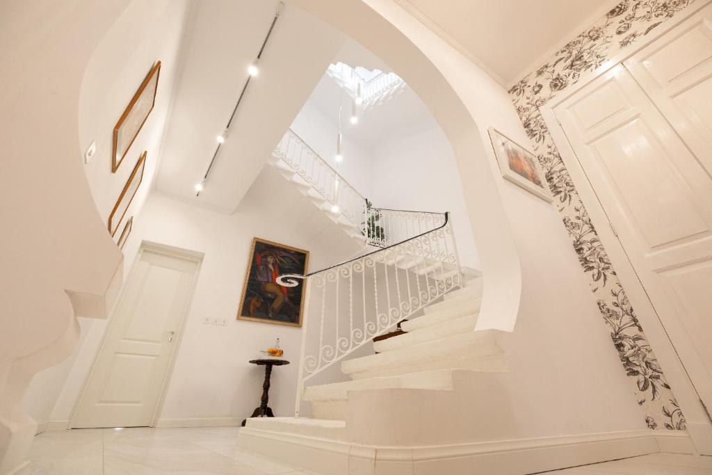 a white staircase in a home with an archway at Encanto Townhouse Sliema in Sliema