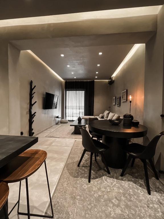 ein Wohnzimmer mit einem Tisch, Stühlen und einem Sofa in der Unterkunft CASAGOLD Glyfada Luxury Apartment Near The Sea in Athen