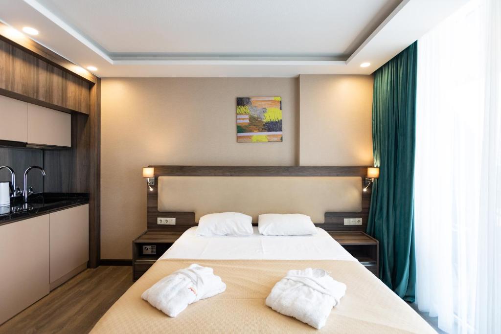 1 dormitorio con 2 toallas blancas en una cama en SUNRISE APART-HOTEL, en Batumi