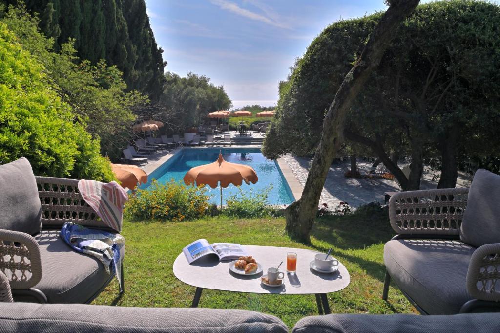 a table with food on it next to a swimming pool at Hôtel Pietracap in Bastia