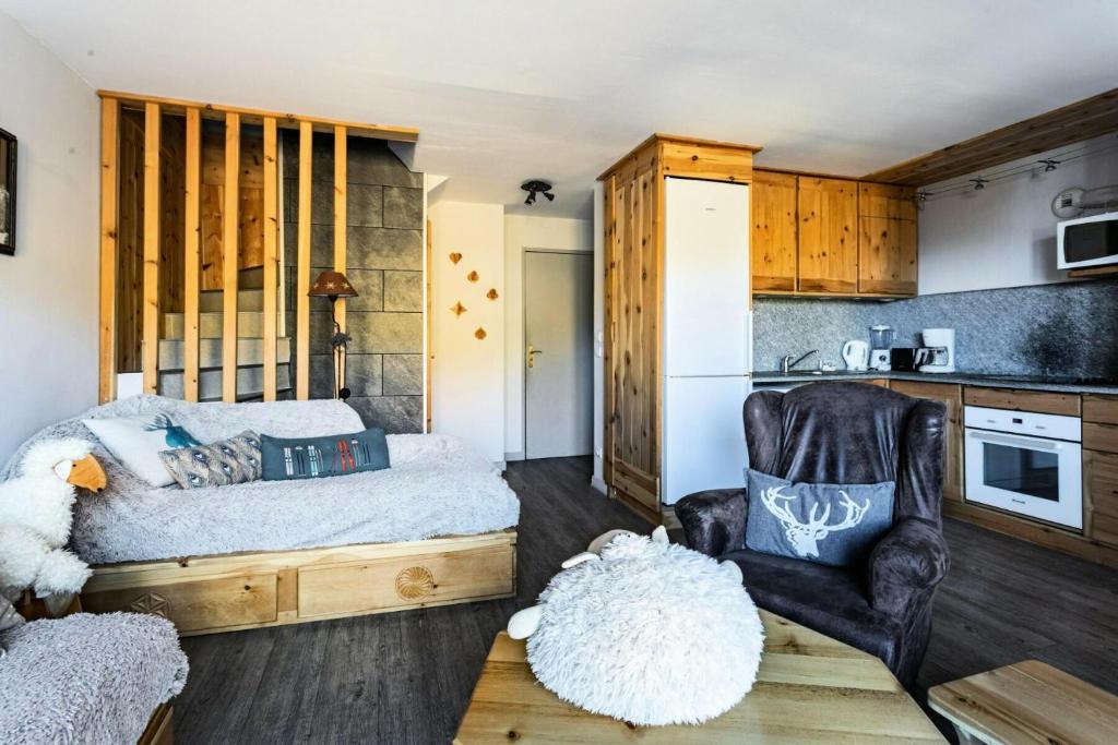 une chambre avec un lit et une chaise et une cuisine dans l'établissement Résidence L'Albane - maeva Home - Appartement spacieux et chaleureux 4 pièces 9 personnes - Exclusive - super Home MAE-1637, à Vars