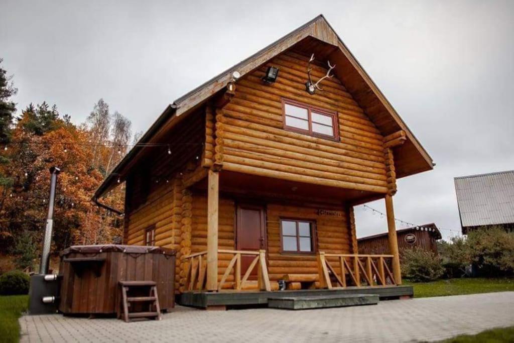a log cabin with a large porch and a large window at Silamalas in Tukums