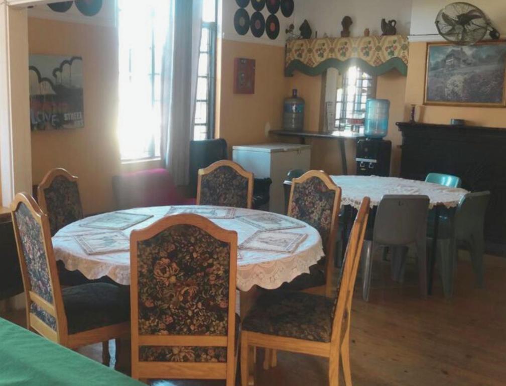 une salle à manger avec une table et des chaises ainsi qu'une cuisine dans l'établissement Ben Your Friend Youth Foundation, au Cap