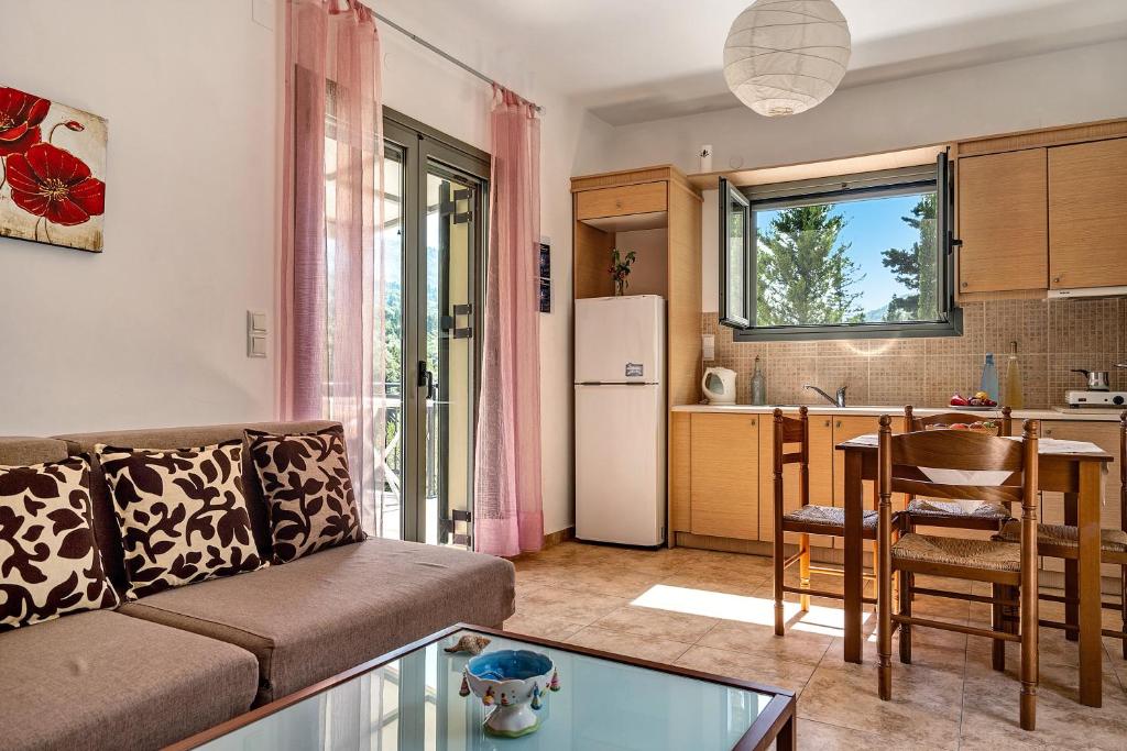 een woonkamer met een bank en een keuken bij Alkionides Apartment 1 in Ayios Nikitas