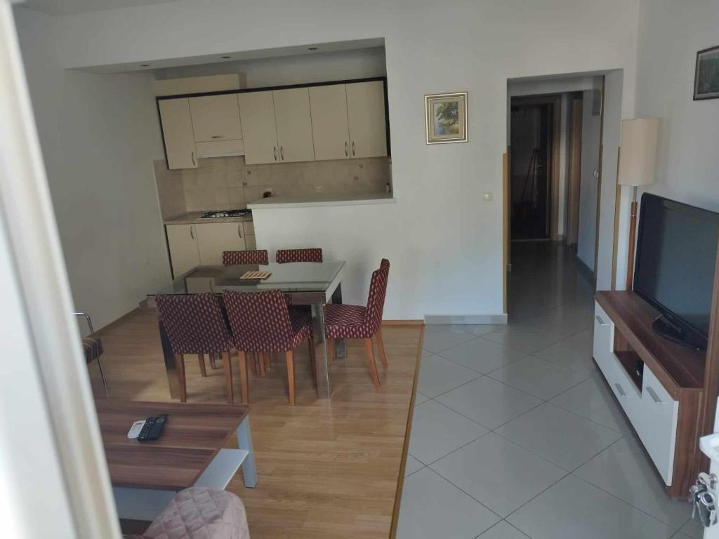 a living room with a table and chairs and a television at Apartment Štrbić in Ploče