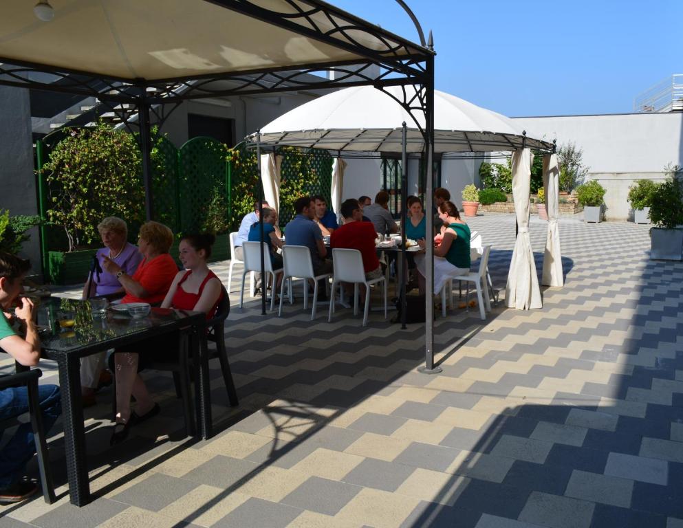 grupa ludzi siedzących przy stołach na patio w obiekcie Ilga Hotel w mieście Collecchio