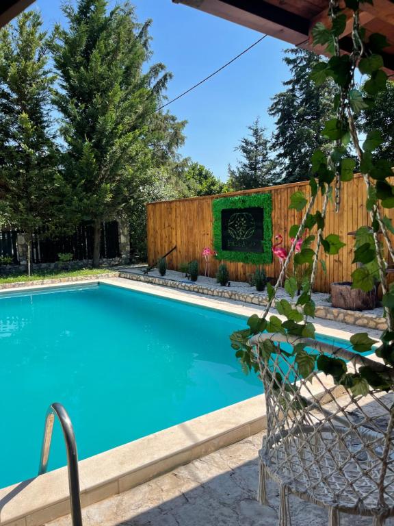 a swimming pool in a backyard with a wooden fence at Vila Aria 