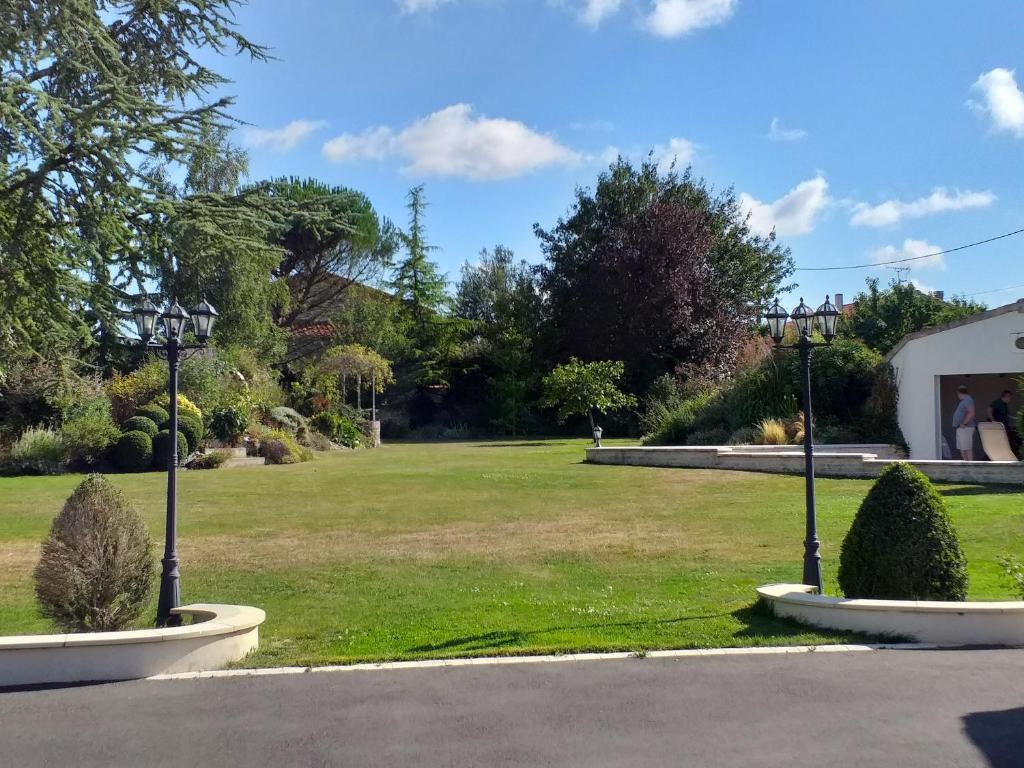 ein Park mit zwei Büschen im Gras in der Unterkunft Maison Coquelicot in Saint-Georges-du-Bois