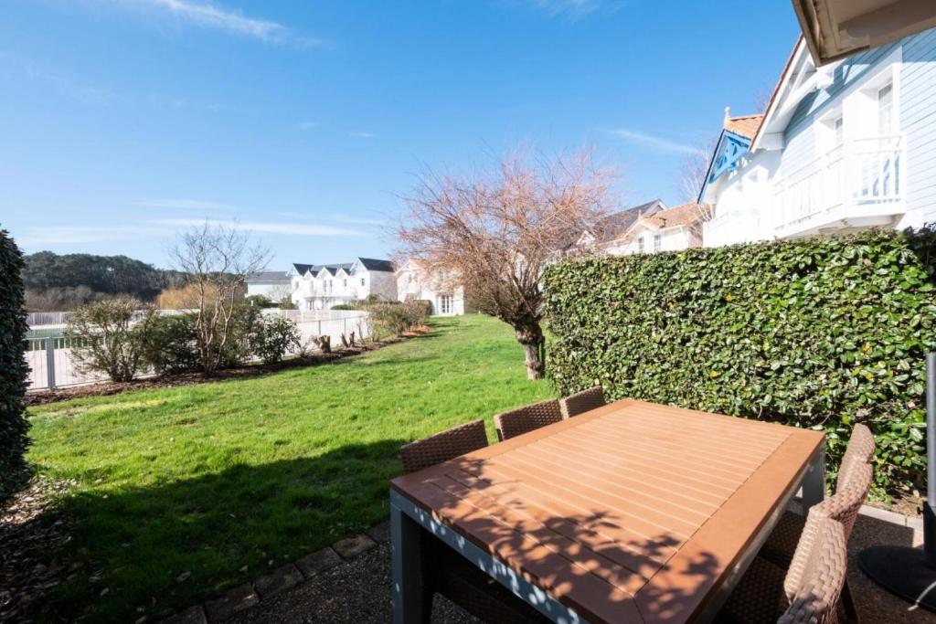 - une table et des chaises sur une terrasse avec une cour dans l'établissement Les Maisons de Port Bourgenay - maeva Home - Maison 3 Pièces 6 Personnes - Sélection MAE-5504, à Talmont-Saint-Hilaire