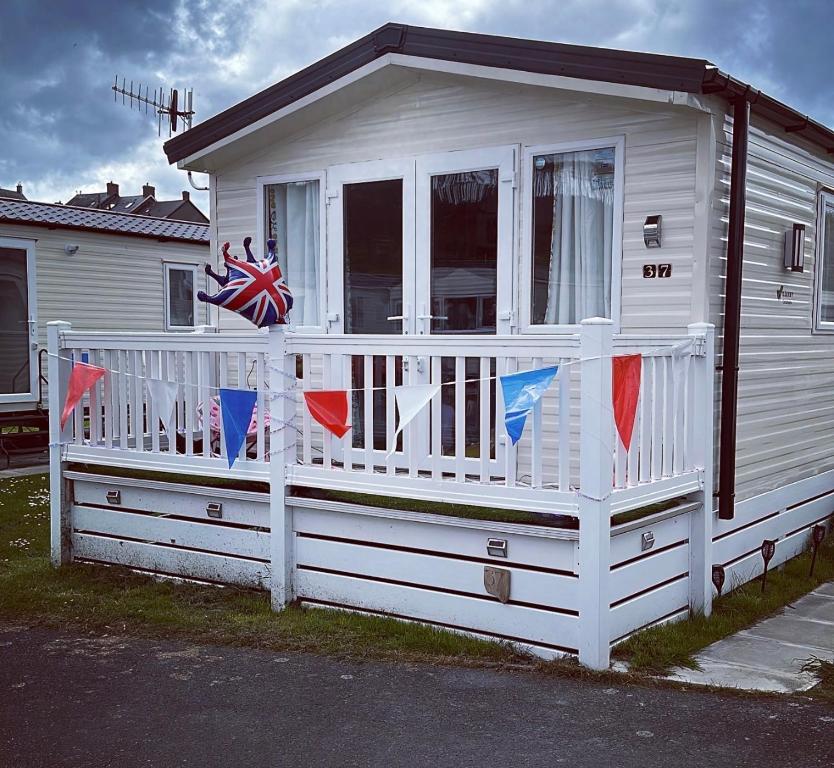a white house with a porch with a flag on it at Powys 37 in Borth