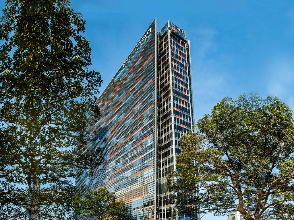 a tall building with trees in front of it at Pullman Saigon Centre in Ho Chi Minh City