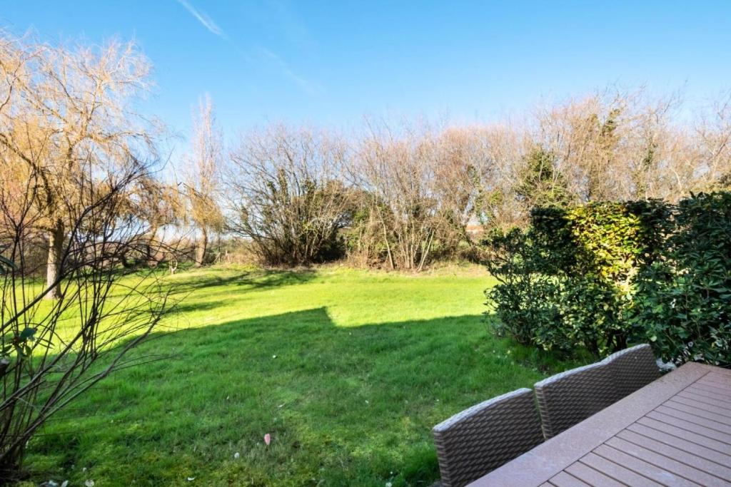 une cour verdoyante avec un banc dans l'herbe dans l'établissement Les Maisons de Port Bourgenay - maeva Home - Maison 3 pièces 6 personnes - Sélection MAE-5828, à Talmont-Saint-Hilaire