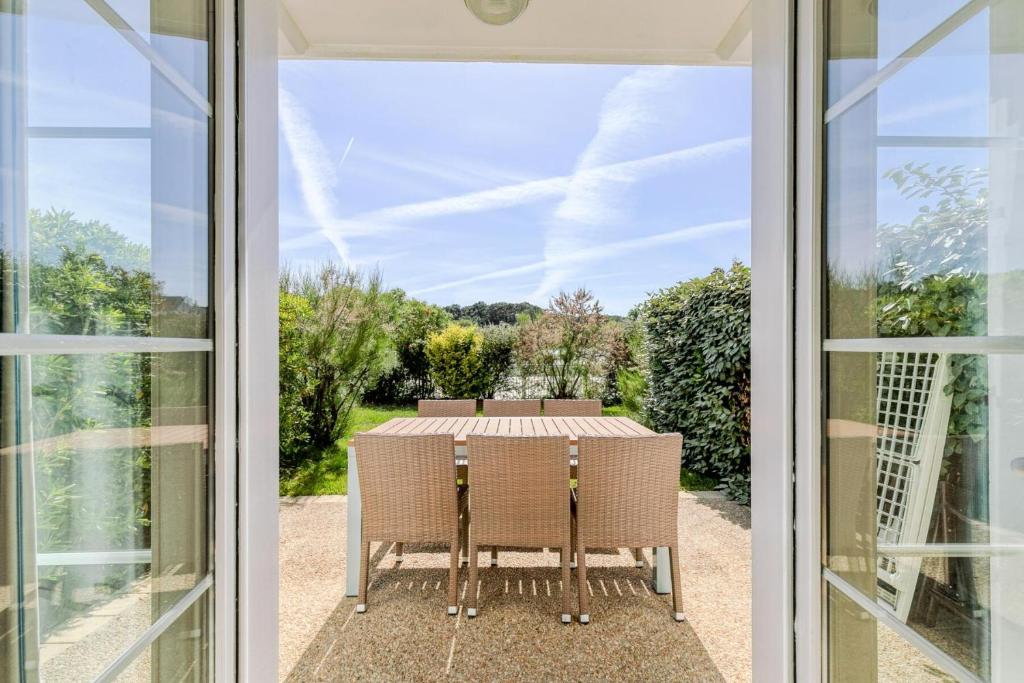 a glass door leading into a patio with a table and chairs at Les Maisons de Port Bourgenay - maeva Home - Maison 3 pièces 6 personnes - Sélection MAE-6402 in Talmont