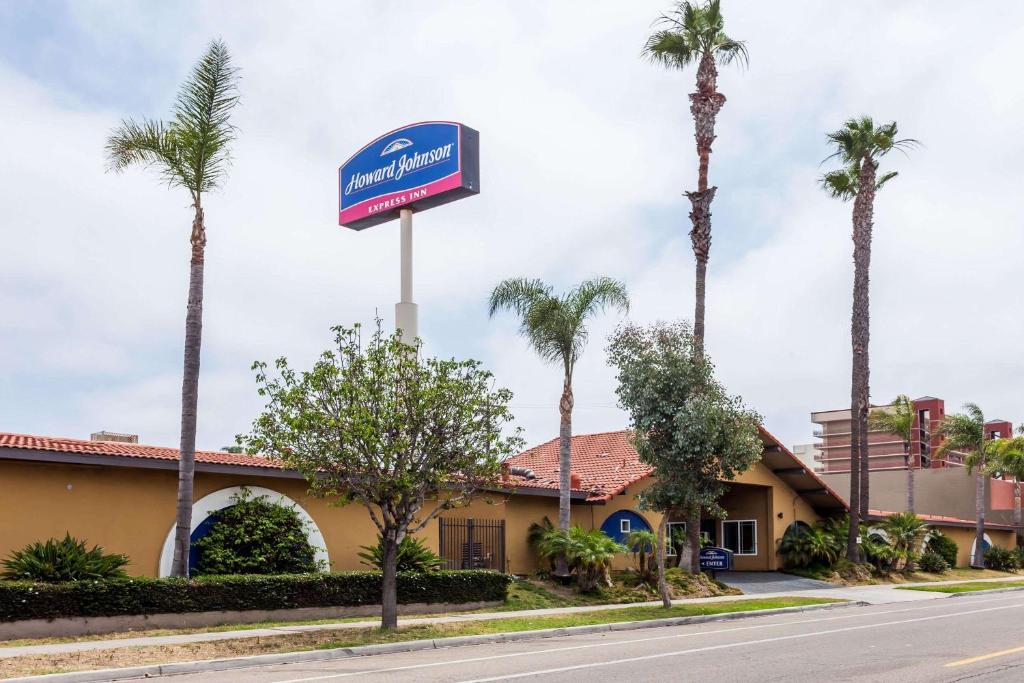 un cartel frente a un hotel con palmeras en Howard Johnson by Wyndham National City/San Diego South, en National City