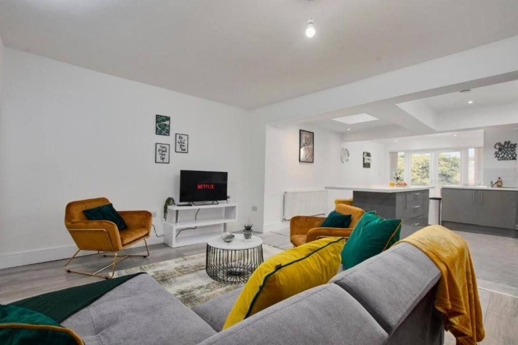 a living room with a couch and chairs and a tv at The Stunning Central Rugby Gem - Sleeps 10 in Rugby