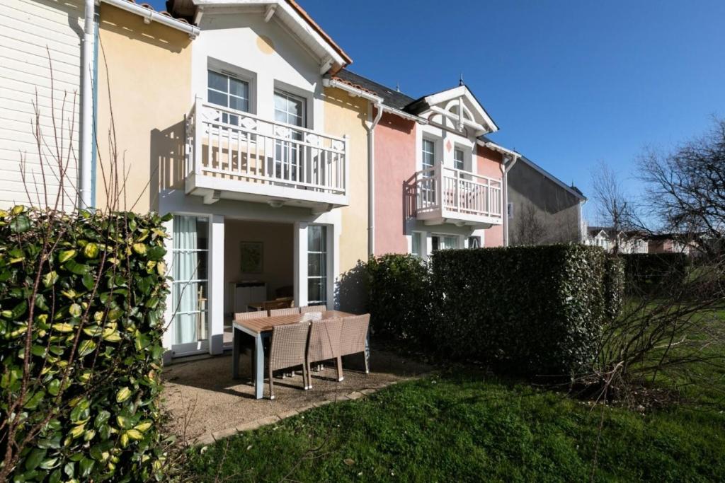 une maison avec une table devant elle dans l'établissement Les Maisons de Port Bourgenay - maeva Home - Maison 3 pièces 6 personnes - Sélection MAE-6434, à Talmont-Saint-Hilaire