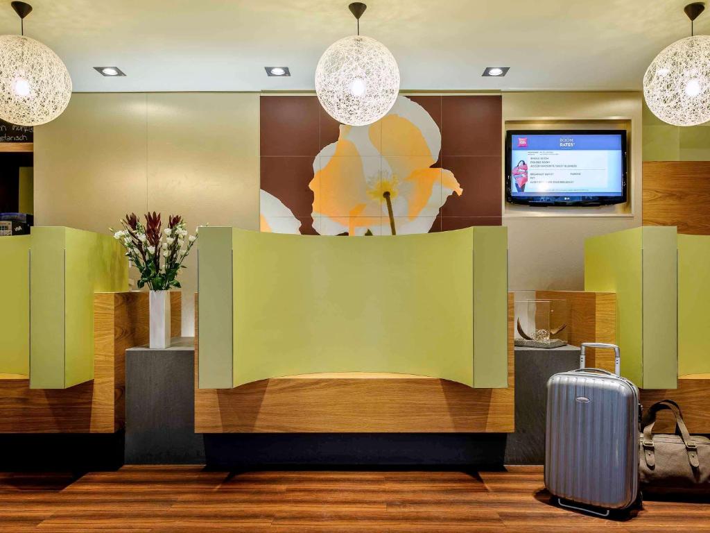 a lobby with a waiting area with a suitcase at ibis Essen Hauptbahnhof in Essen
