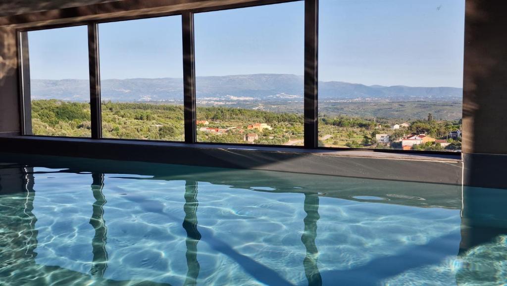 a swimming pool with a view of the mountains at Puro Dão Hotel & Spa in Nelas