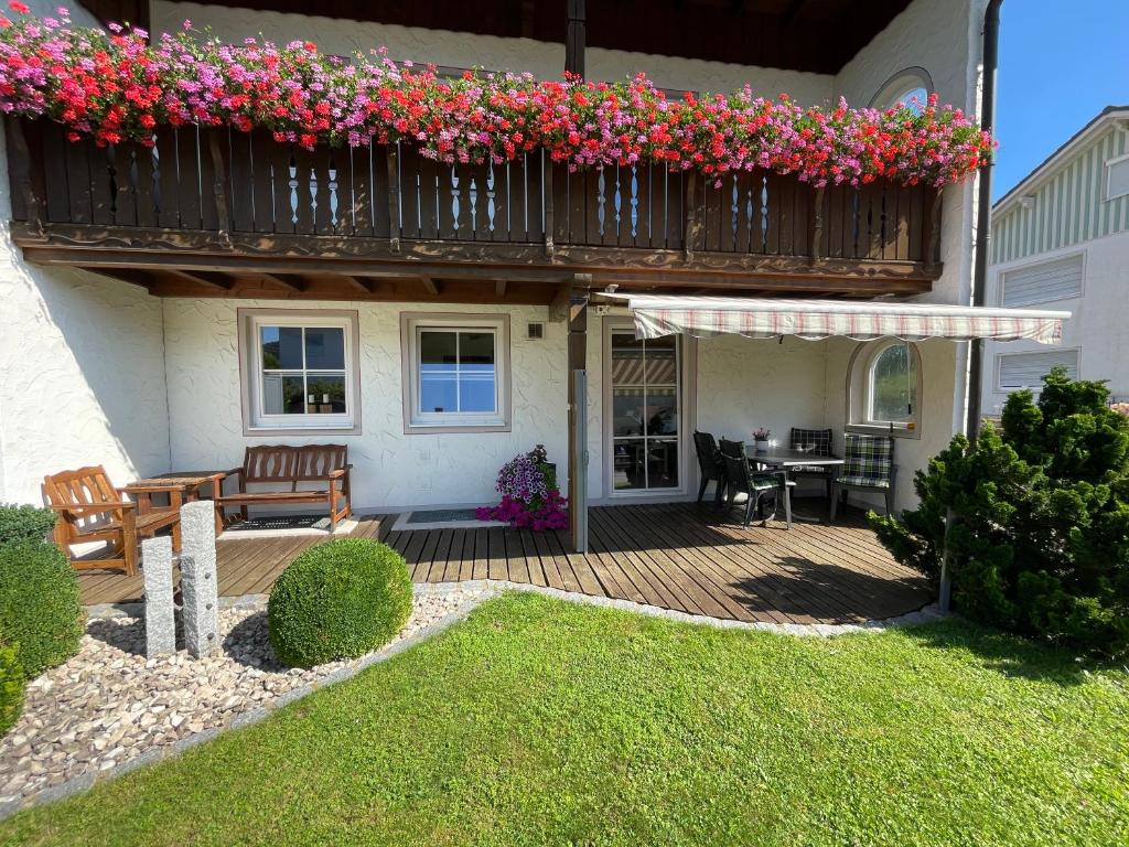 Una casa con una terraza con flores. en Bodos-Auszeit en Weitnau