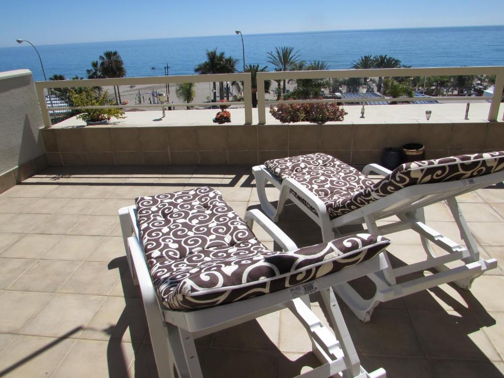 two chairs and a table on a balcony with the ocean at Home4Holidays in Nerja