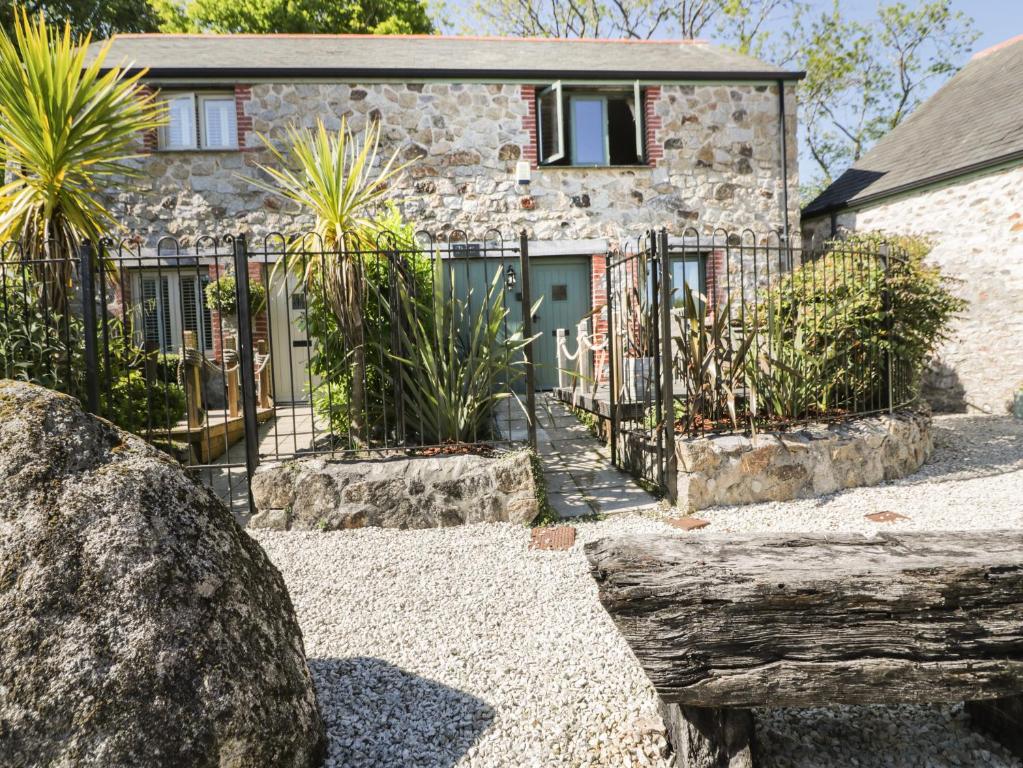 a stone house with a gate in front of it at Pirata in St Austell