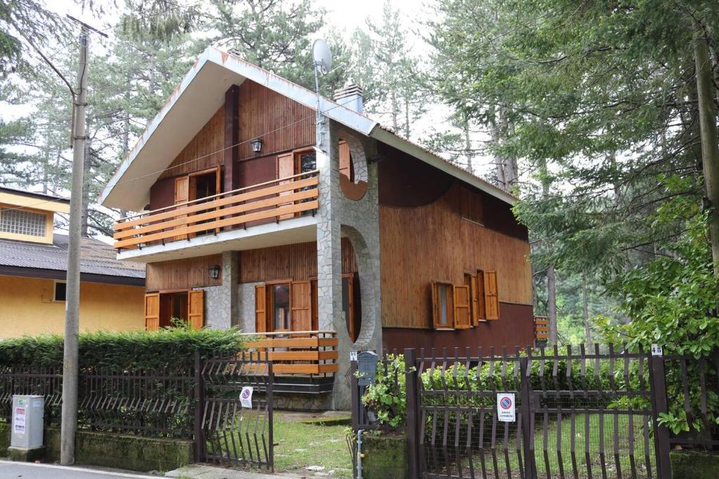 a wooden house with a fence in front of it at Lo Chalet della antica Locomotiva in Camigliatello Silano