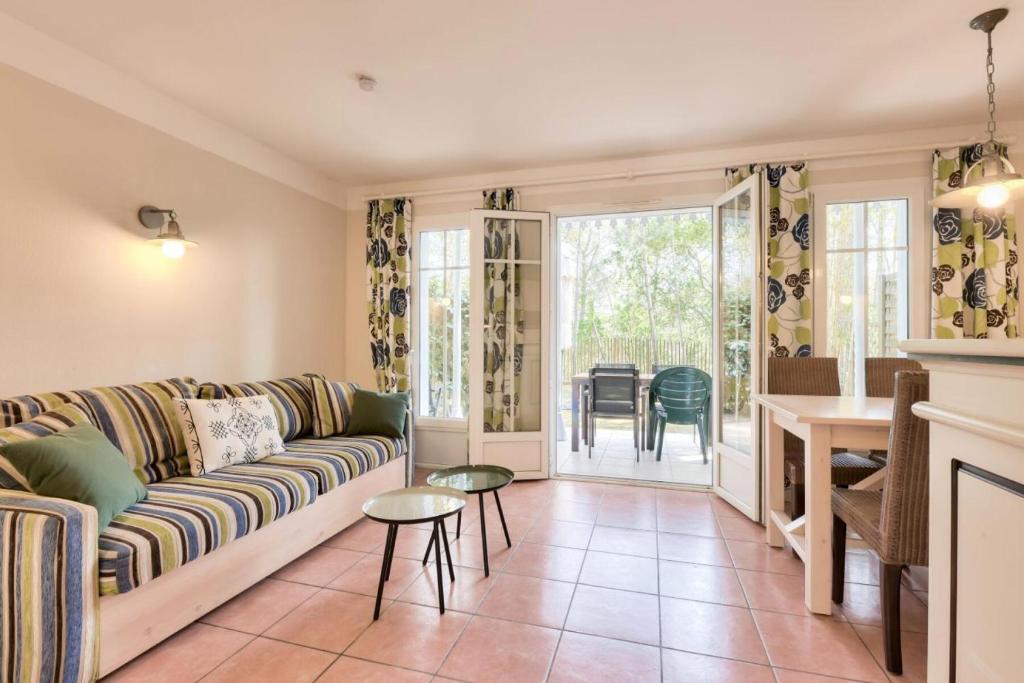 un salon avec un canapé et une table dans l'établissement Les Maisons de Lacanau les Pins - maeva Home - Maison 3 pièces 6 personnes - Sélection MAE-7336, à Lacanau