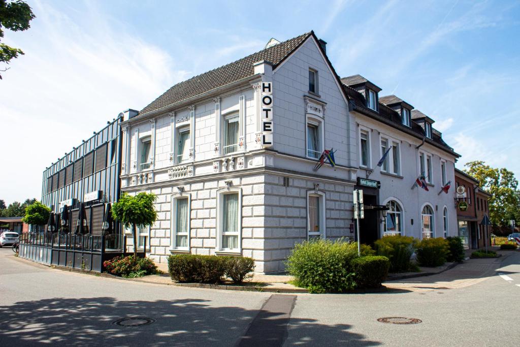 ein weißes Gebäude mit einem Schild an der Seite in der Unterkunft Airport Hotel Jägerhof Weeze in Weeze