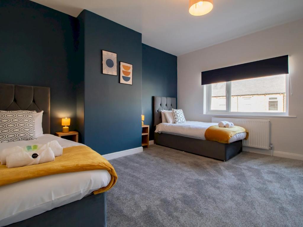 1 dormitorio con 2 camas y paredes azules en Pass the Keys Stylish Terrace with Free Parking, en Blythe