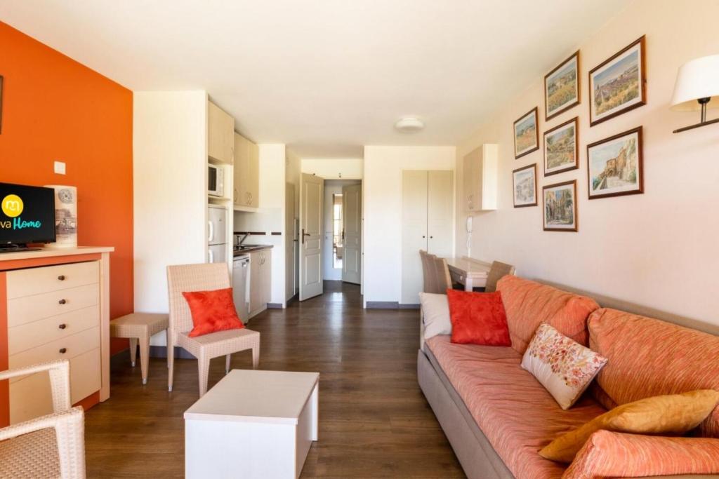 un salon avec un canapé et une cuisine dans l'établissement Résidence le Village de Cap Esterel - maeva Home - Appartement 2 Pièces 7 Personnes avec coin cabine - Sélection MAE-7345, à Saint-Raphaël