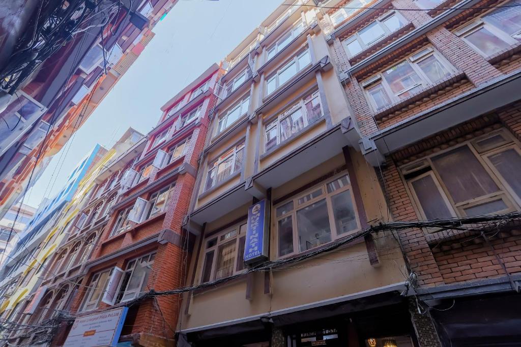 um edifício alto com janelas numa rua da cidade em OYO 800 New Muktinath Hotel em Kathmandu